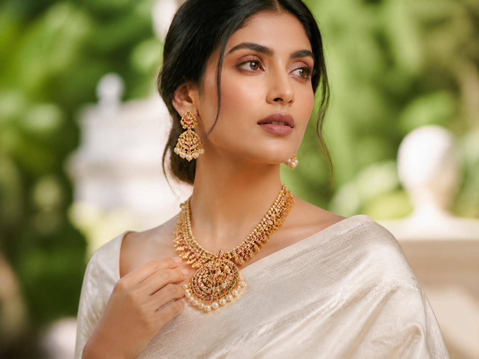 Model wearing an ornate Swarnam gold necklace and earrings
